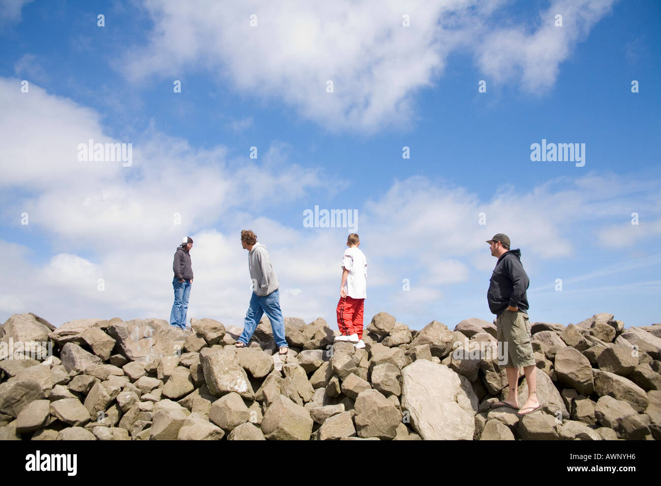 Men walking over rocky terrain Stock Photo
