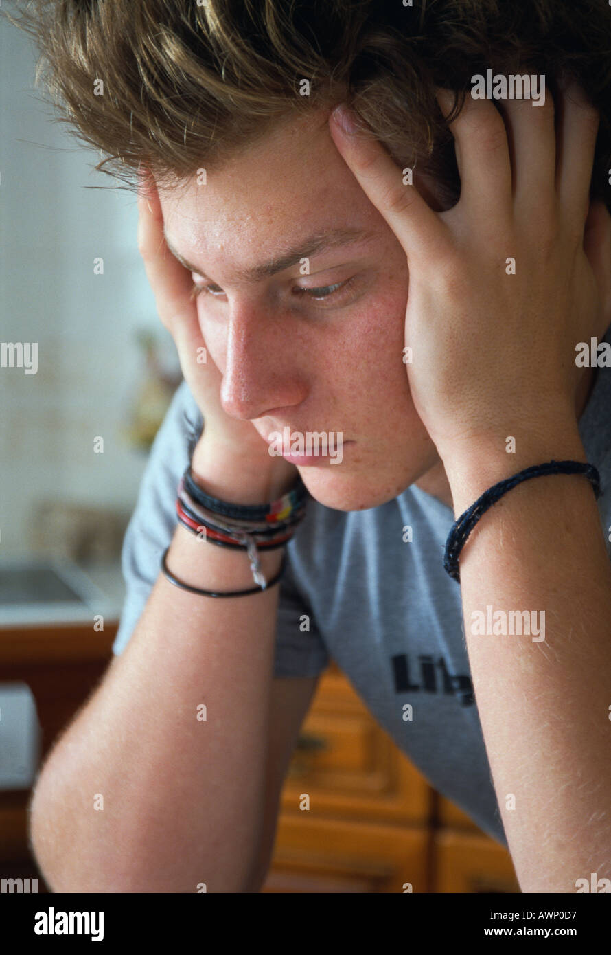 Young man with head in hands in contemplation Stock Photo