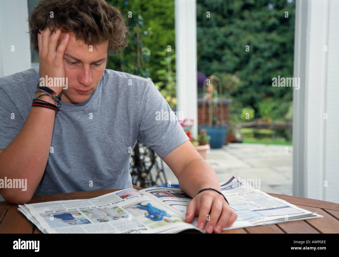 Young man reading a newspaper Stock Photo - Alamy