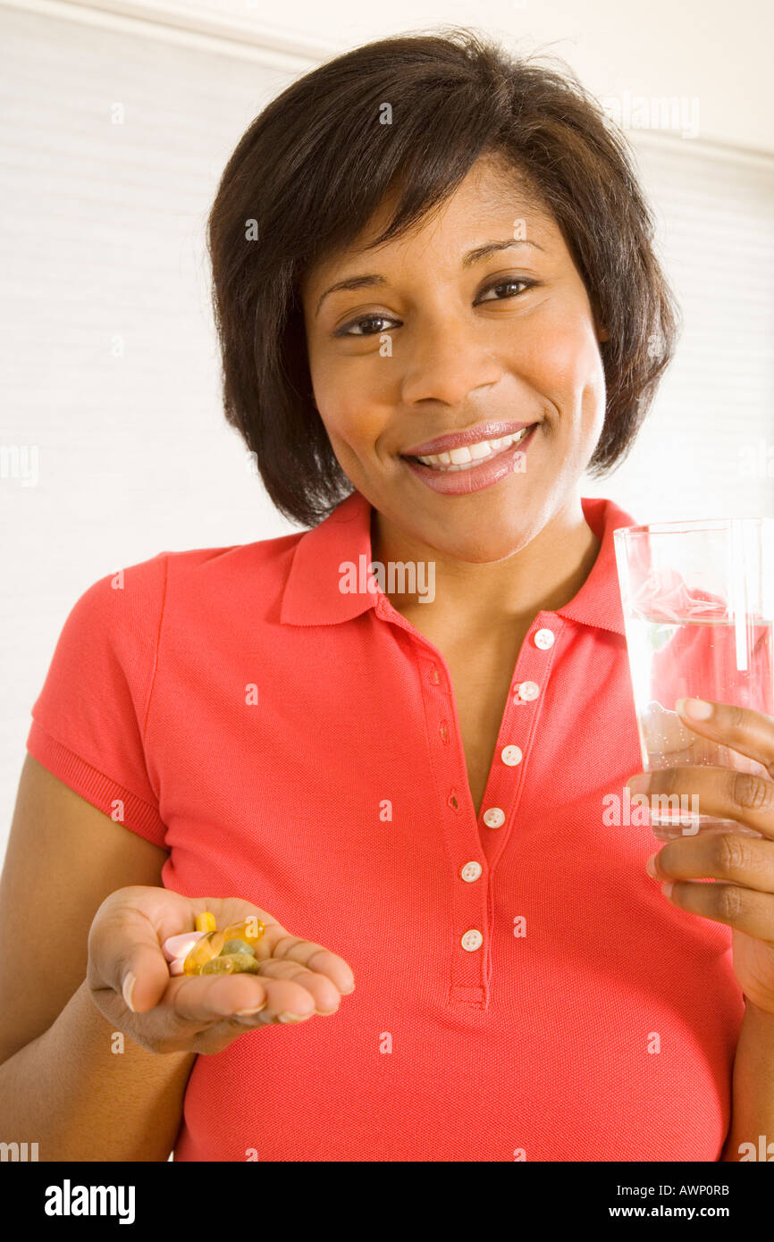 Woman taking handful of pills Stock Photo