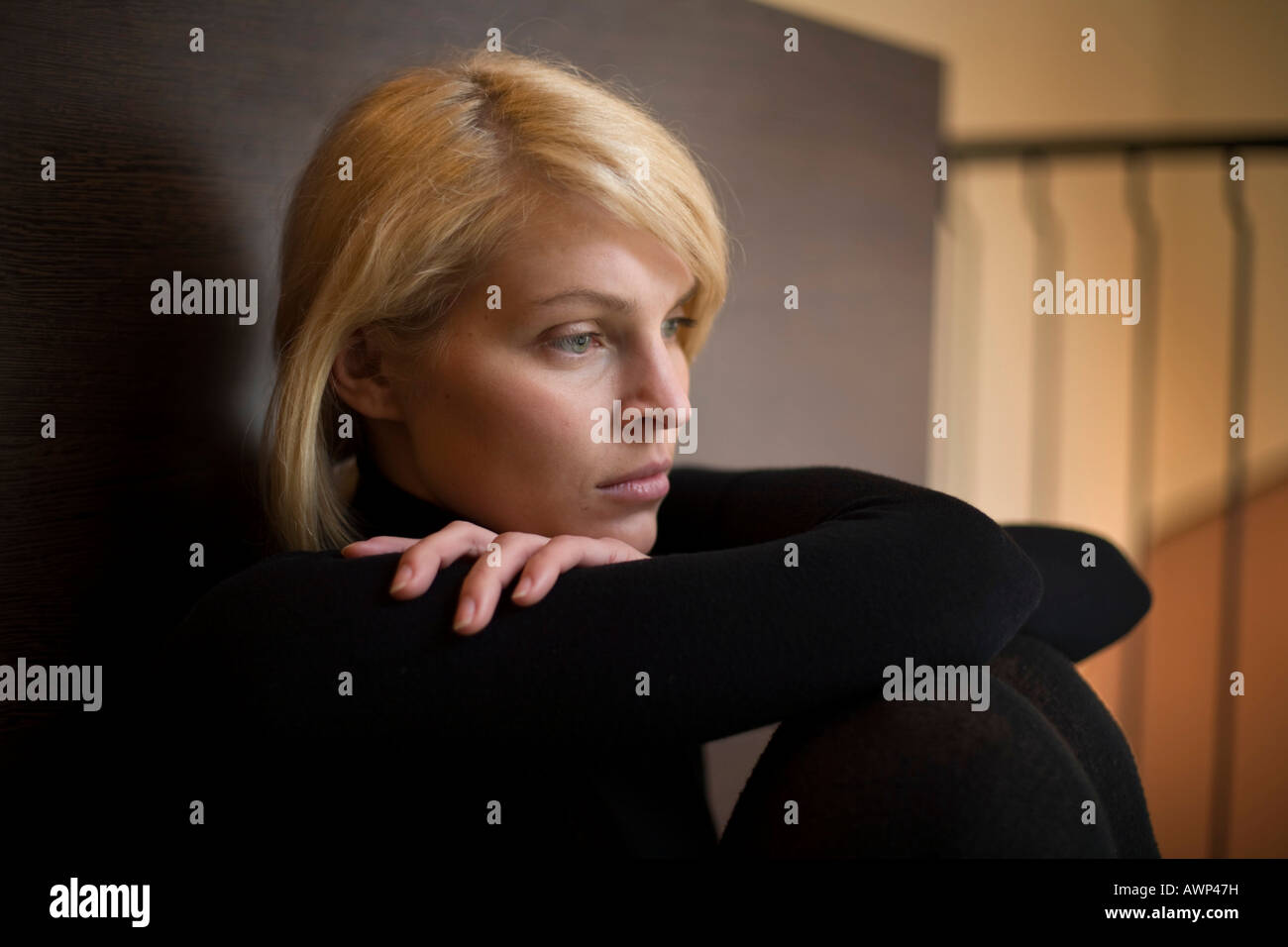 Blonde woman sitting on the floor Stock Photo - Alamy