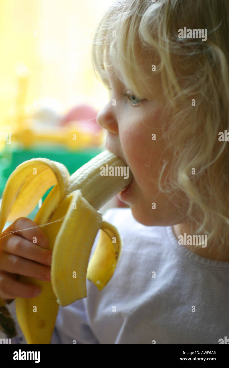 young girl eating banana Stock Photo Alamy