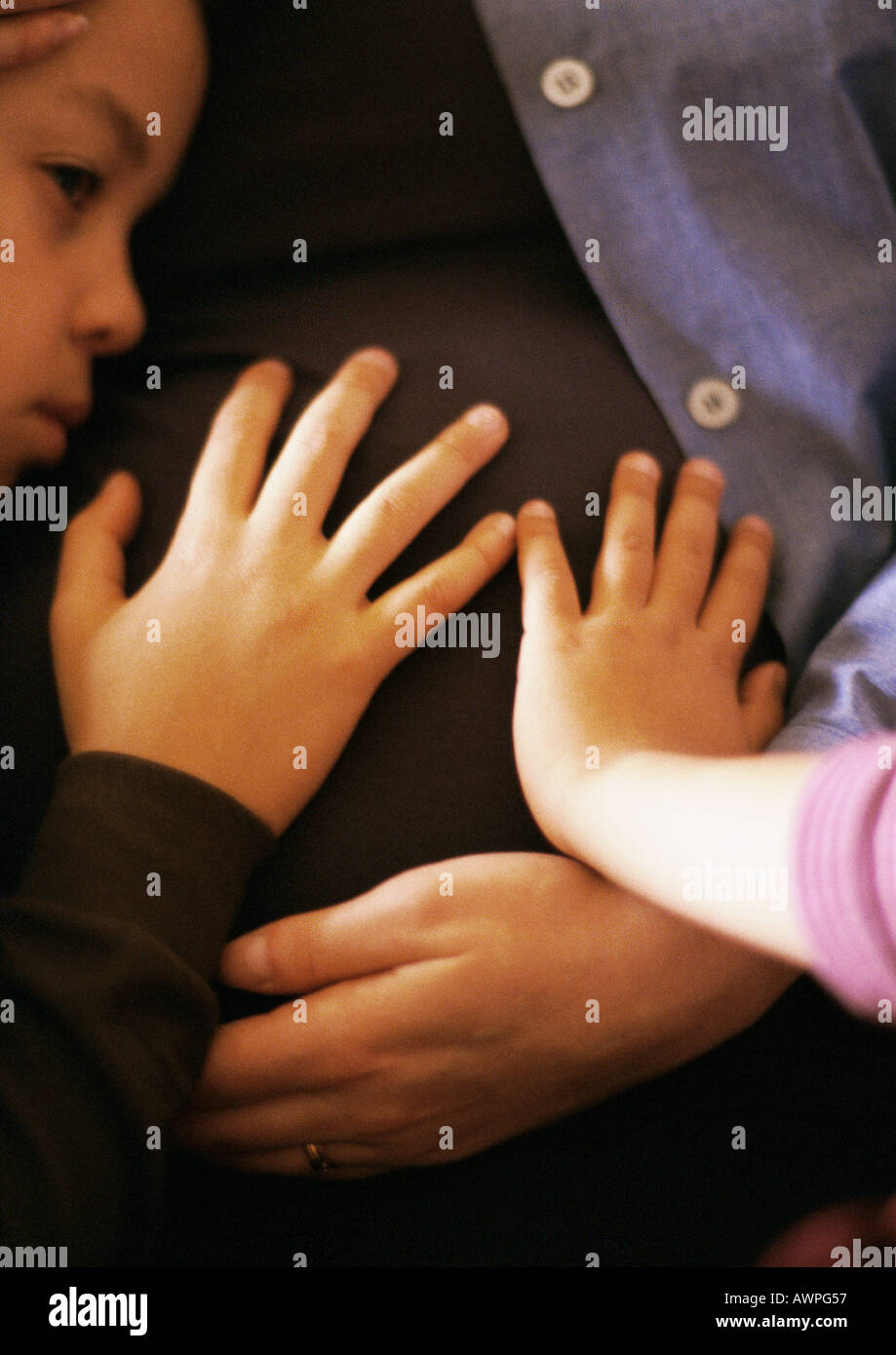 Children touching mother's pregnant stomach, closeup Stock Photo Alamy