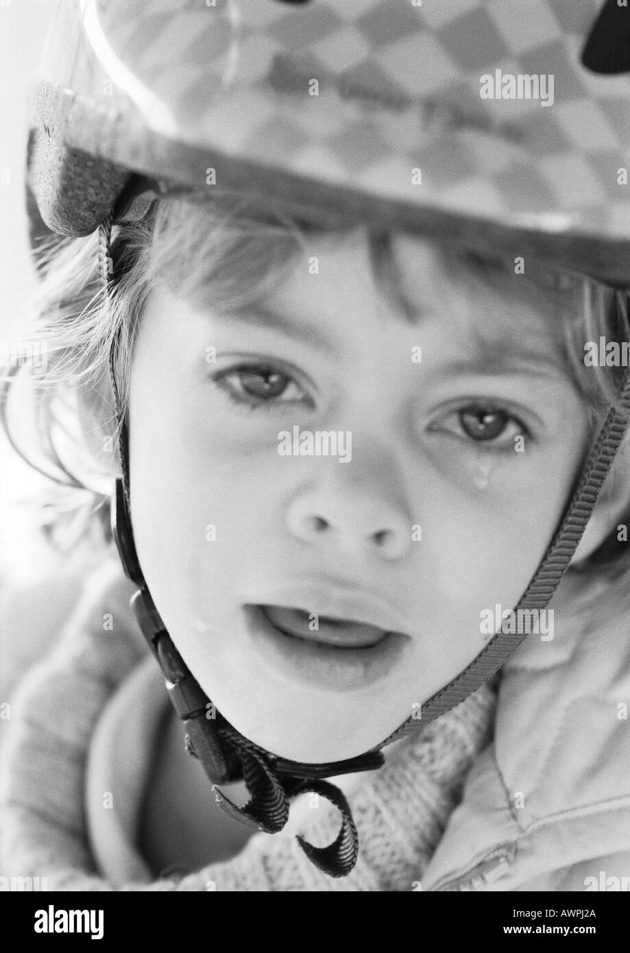 Girl wearing helmet, crying, portrait, b&w Stock Photo