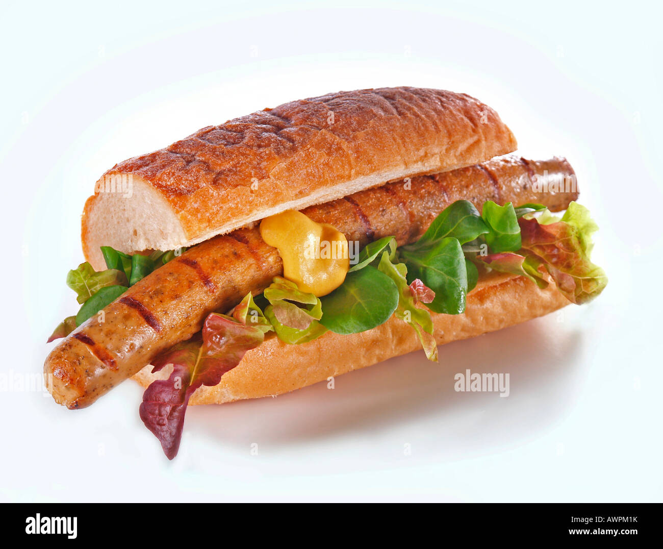 Veggie (tofu) bratwurst, mustard and lettuce on a baguette Stock Photo