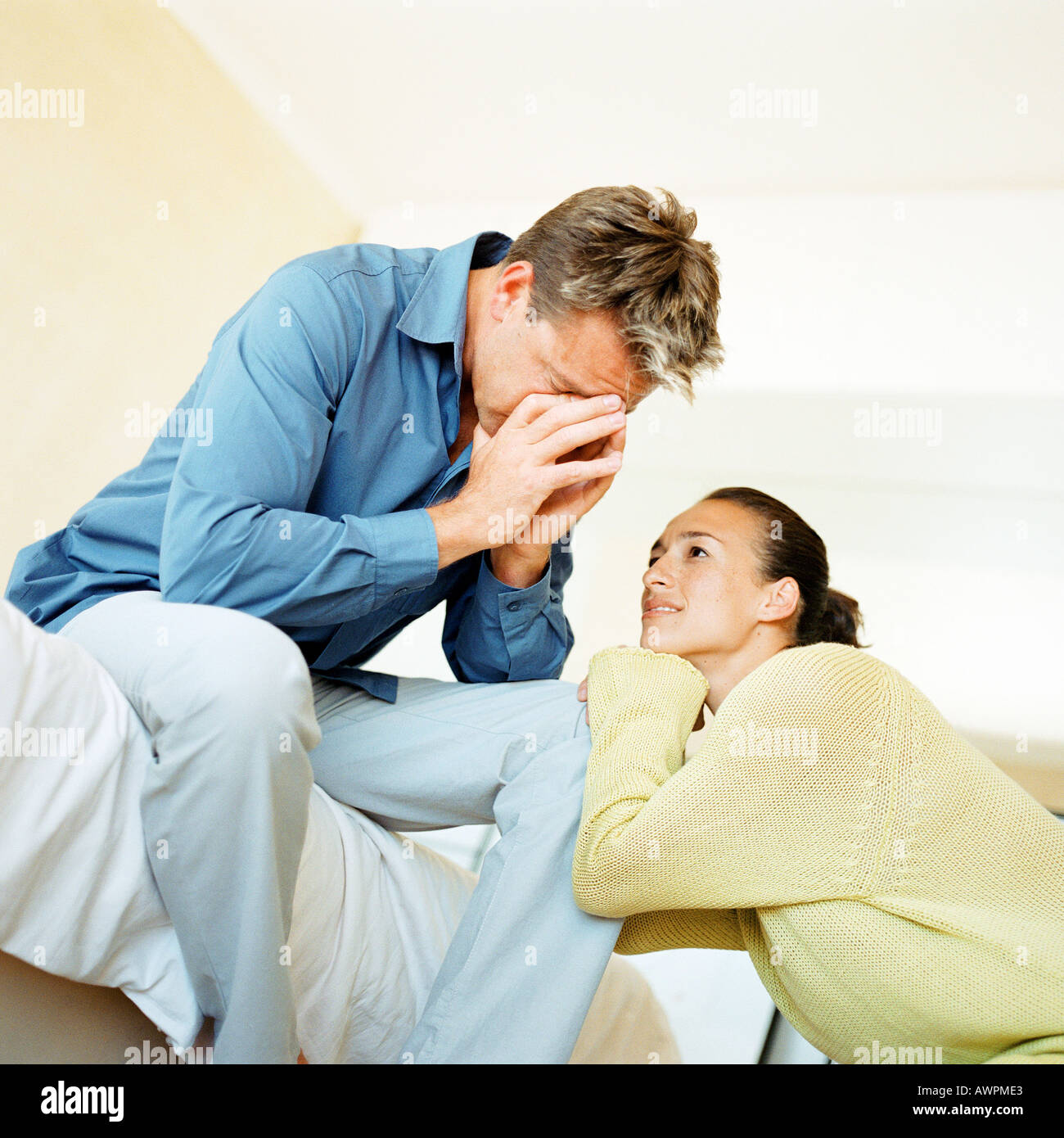 Man Sitting On Edge Of Bed With Hands Over Face Woman Leaning On