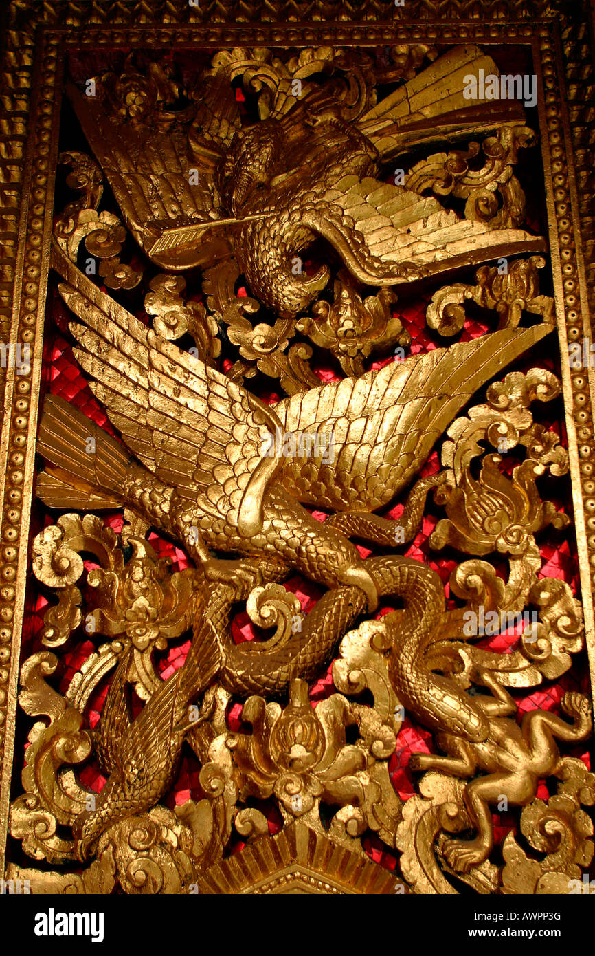 Laos Luang Prabang Wat Haw Pha Bang carved gilded window shutter detail Stock Photo