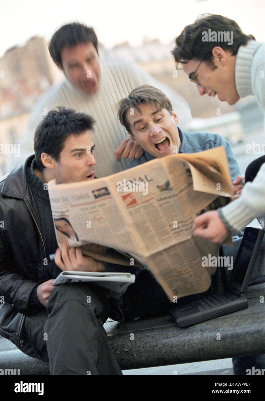 Four men looking at newspaper Stock Photo