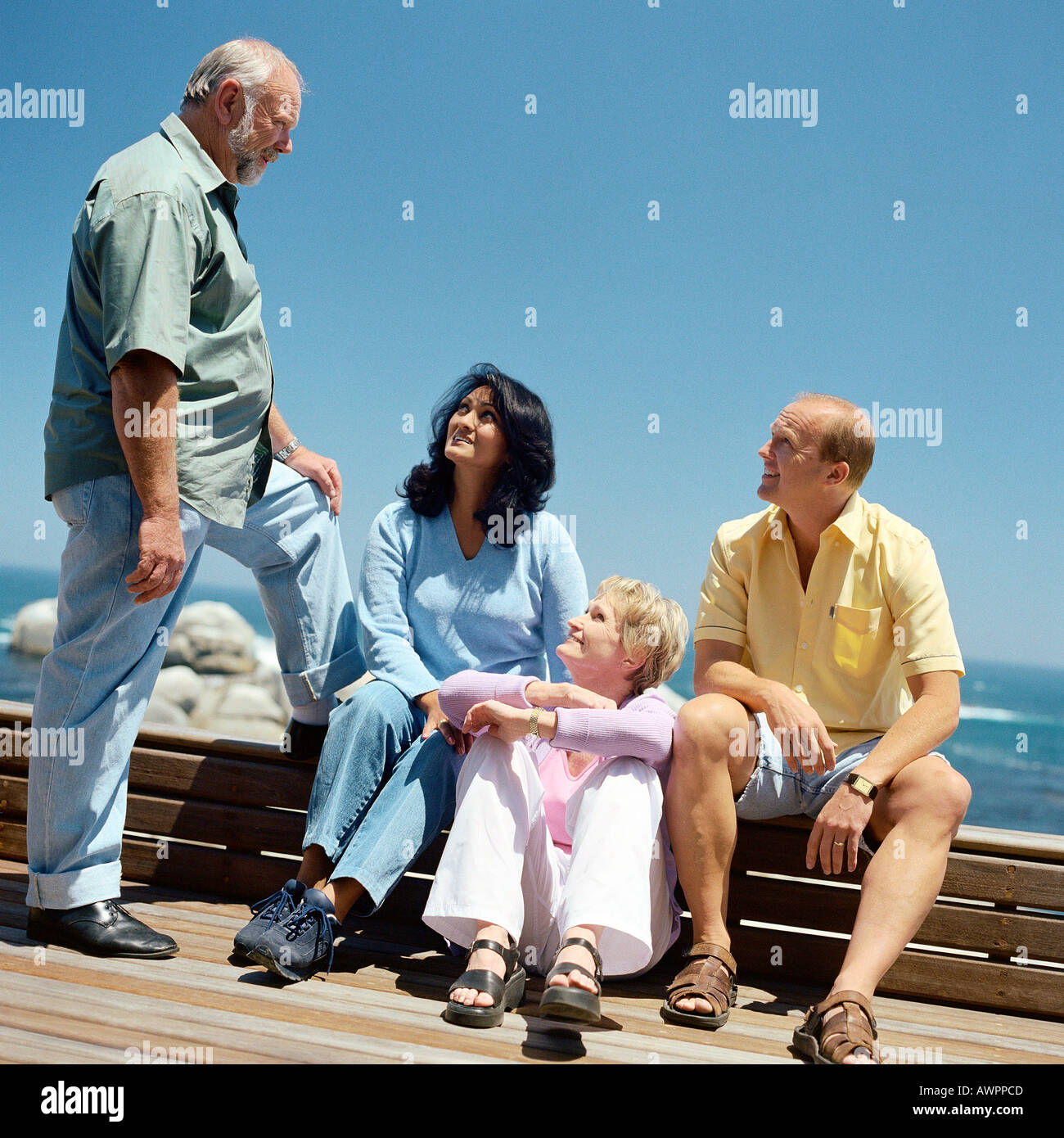 Two mature couples, sea in background Stock Photo
