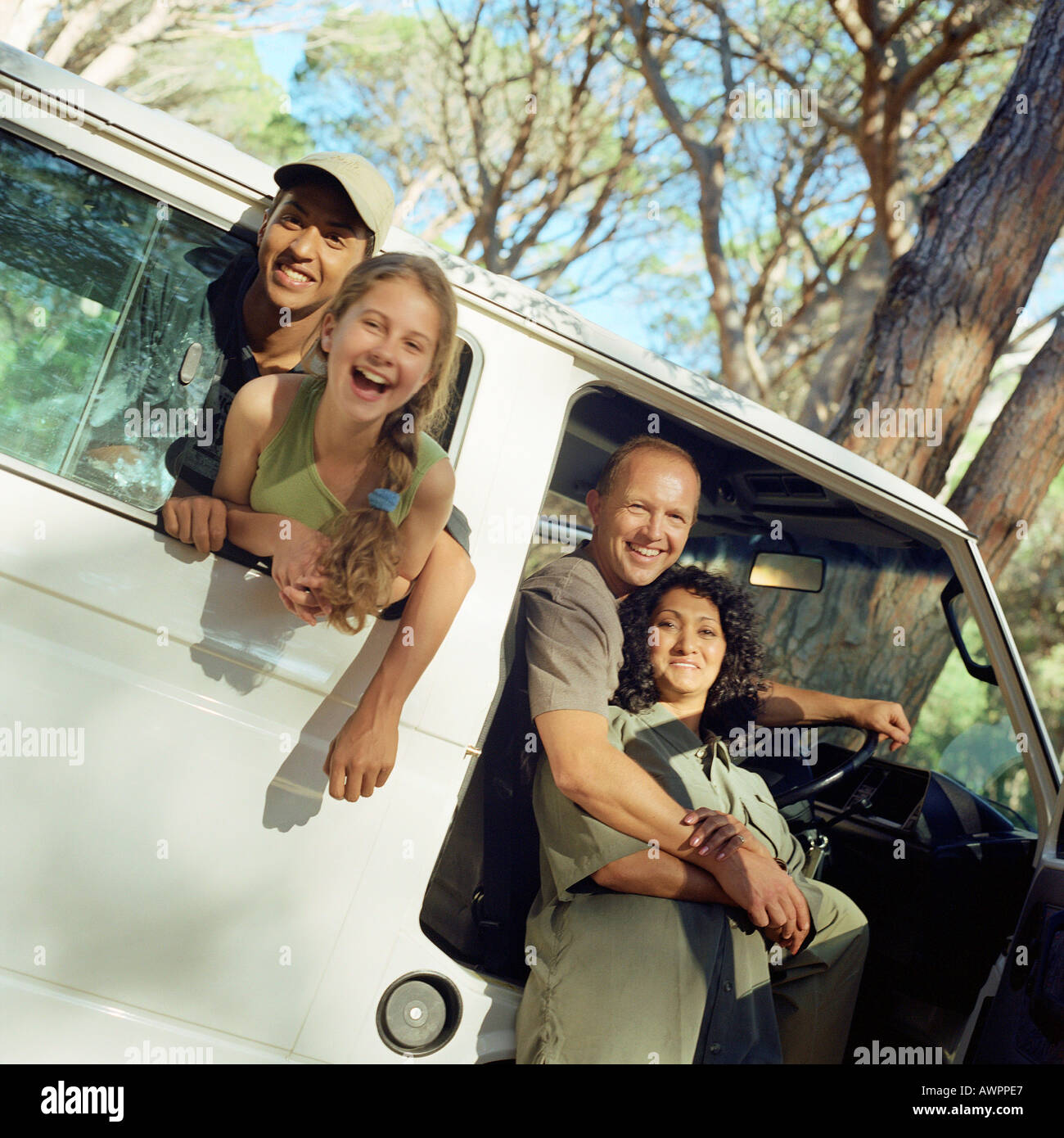 Family portrait, children sticking heads out of van window, parents in open door of van Stock Photo