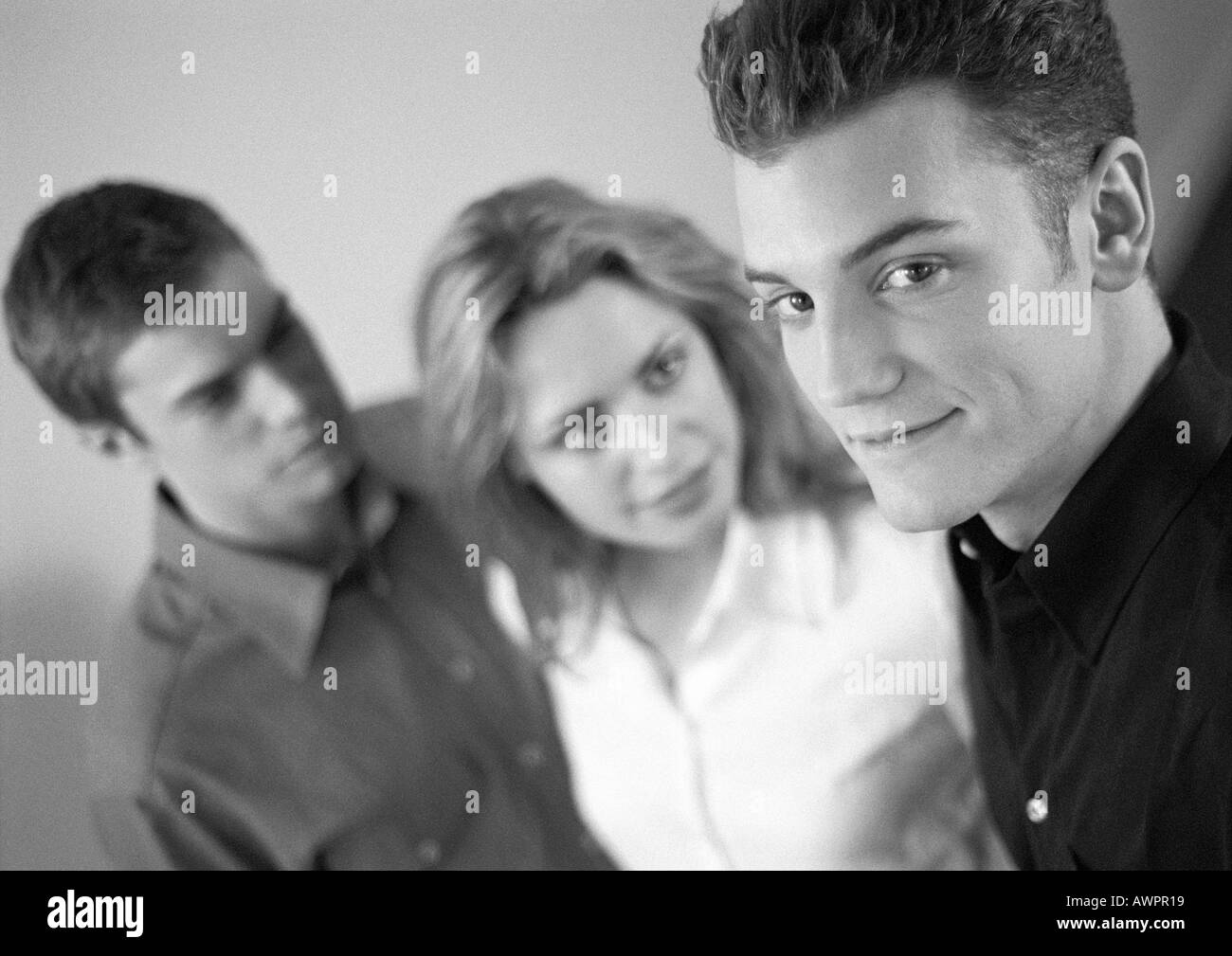 Woman standing between two men, b&w Stock Photo