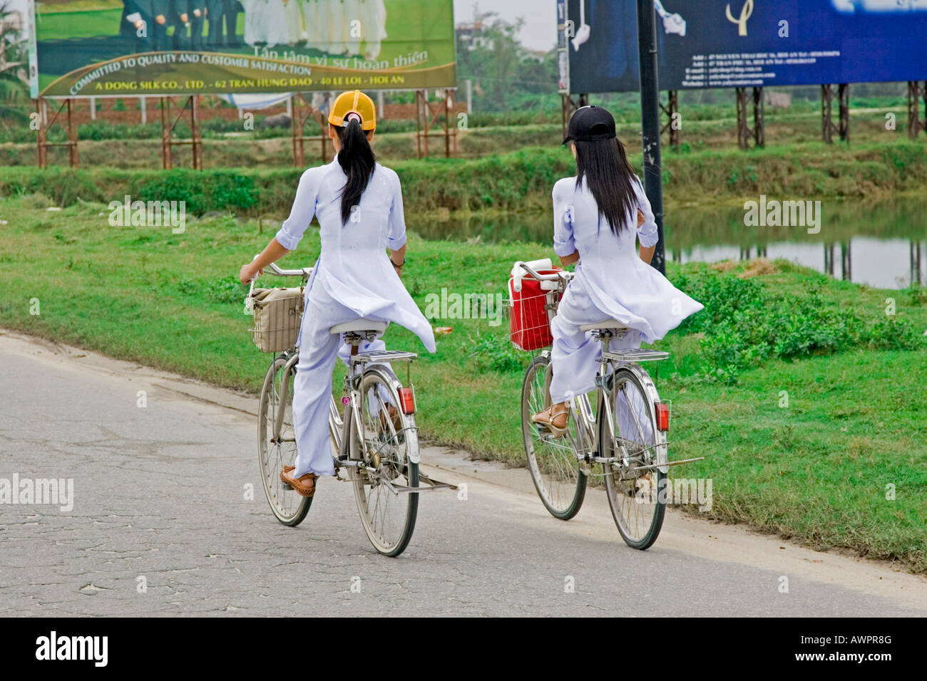Students in the traditional ao dai dress on the way to school Vietnam Stock Photo