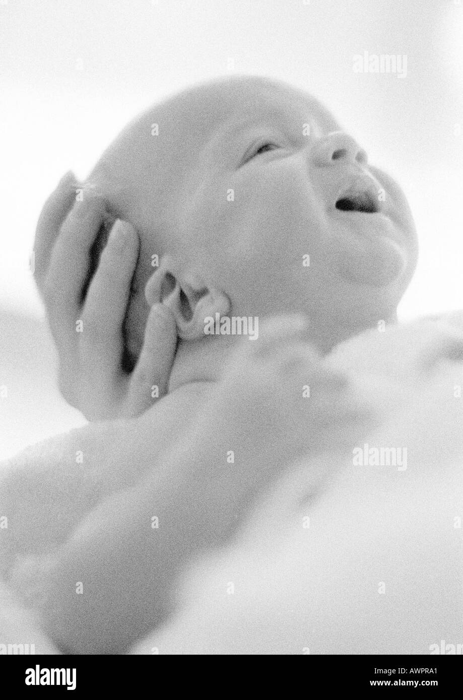 Crying infant in mother's hands, b&w Stock Photo