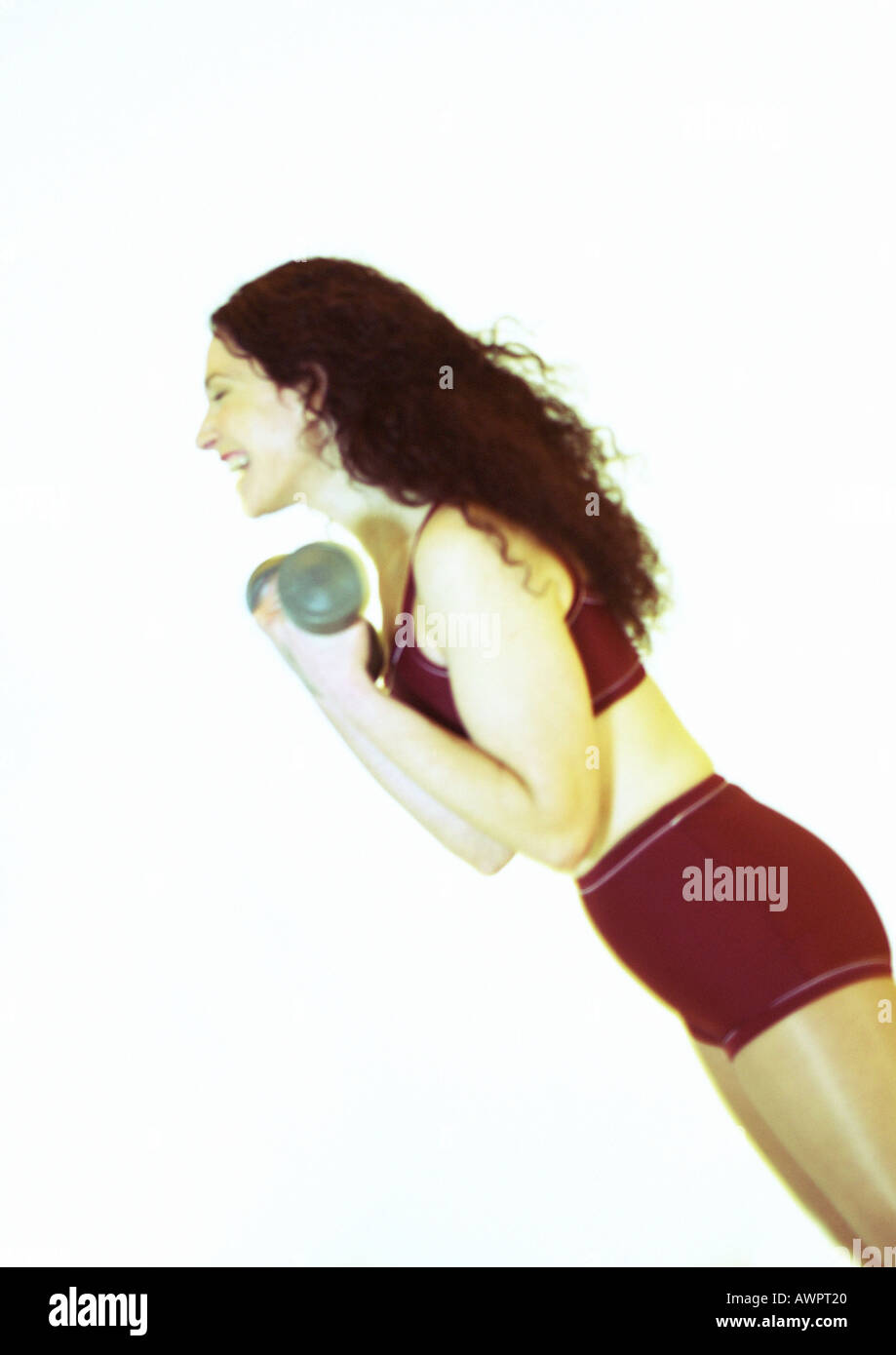 Woman lifting weights and laughing, side view Stock Photo