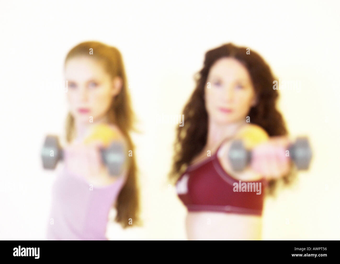 Women holding out barbells Stock Photo