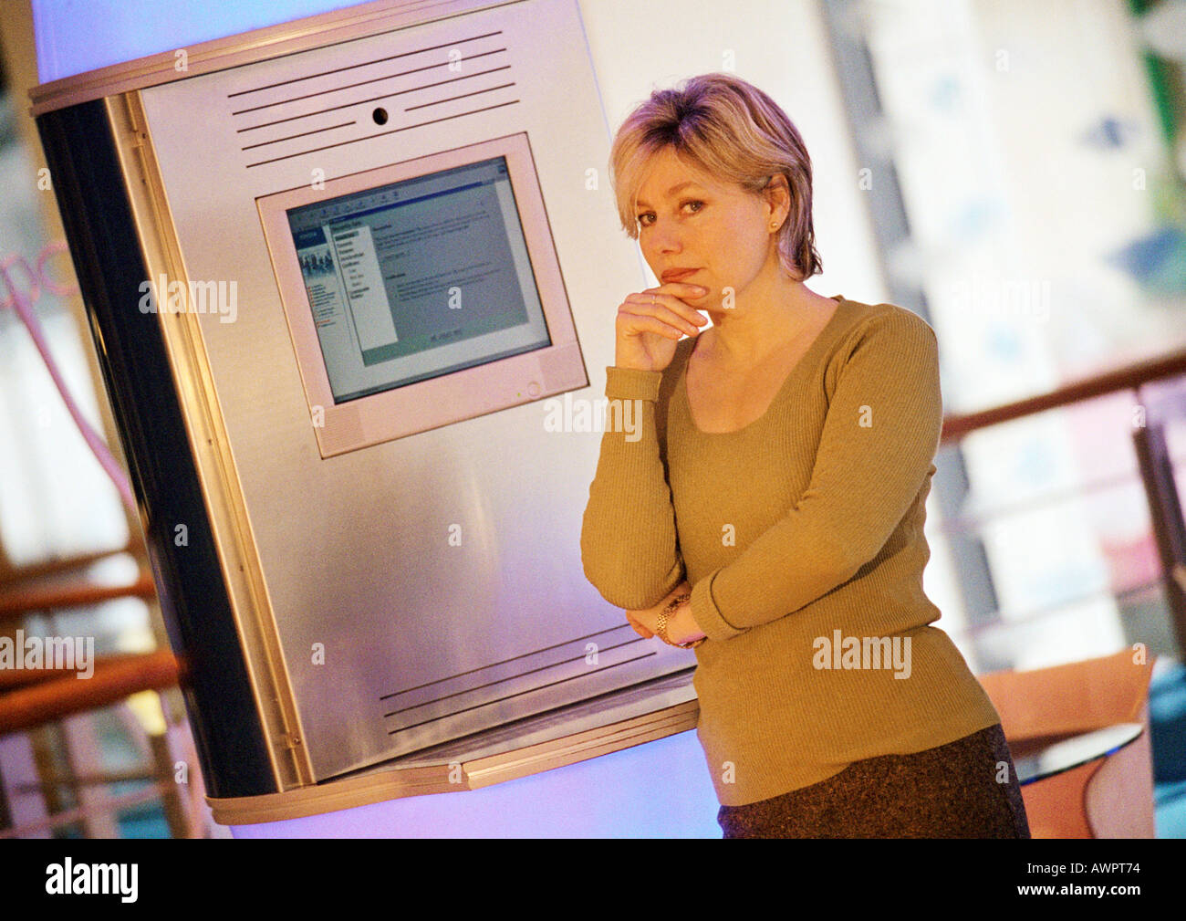 Woman standing in front of computer screen, portrait Stock Photo