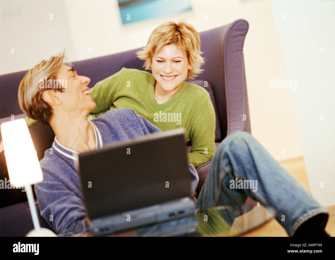 Couple smiling, using laptop Stock Photo