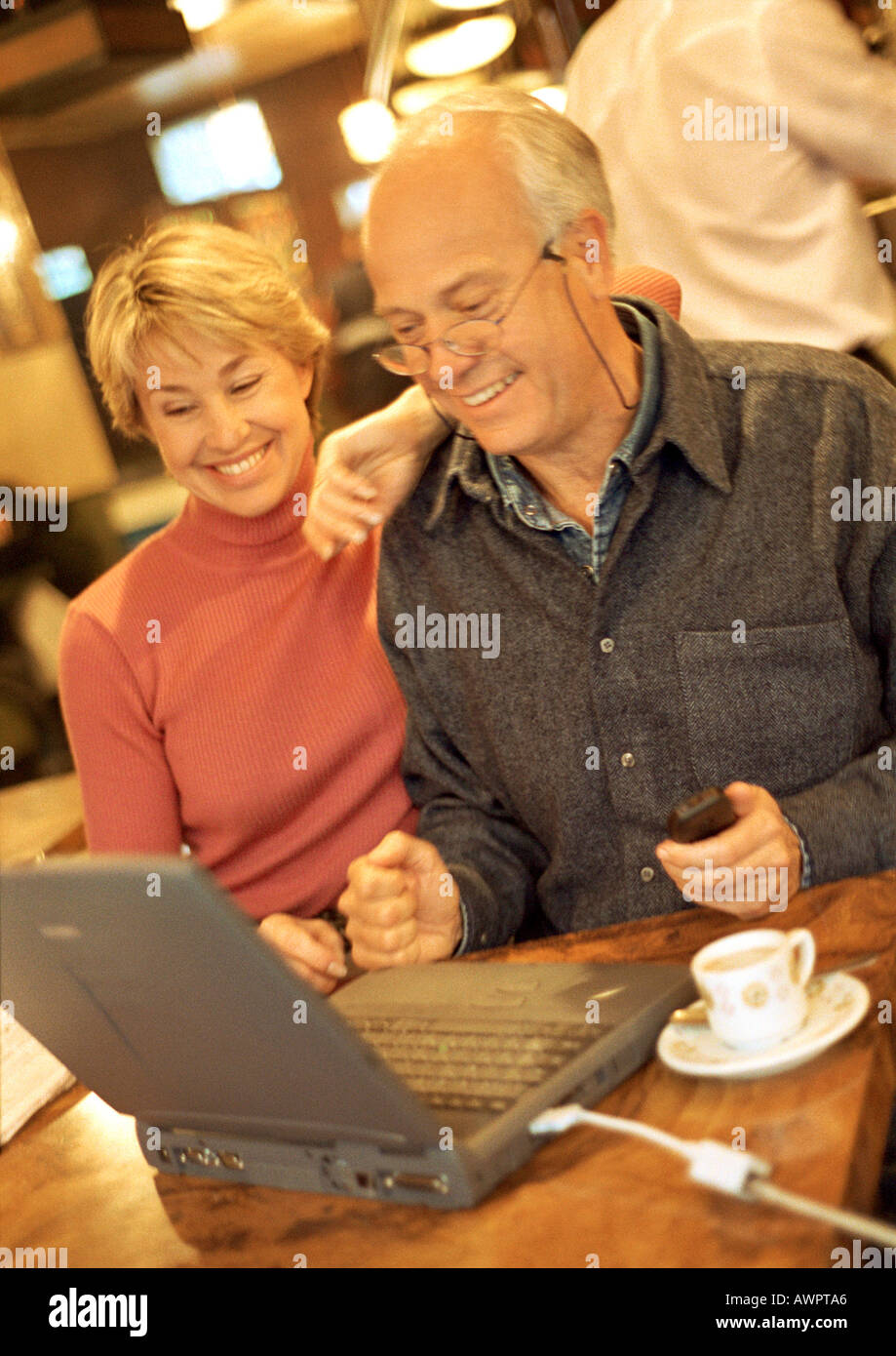 Mature couple in cafŽ using laptop. Stock Photo