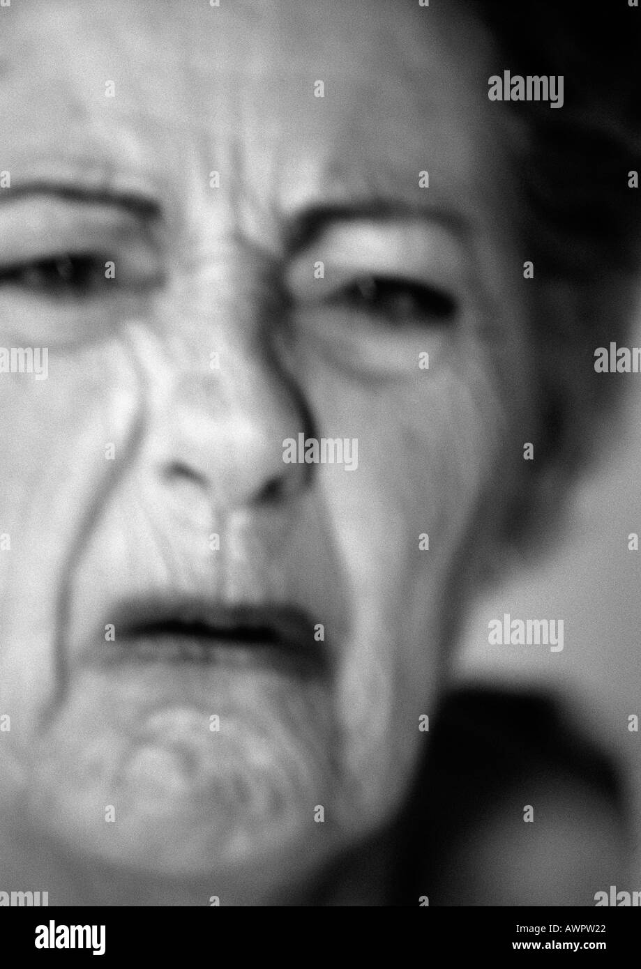 Senior woman frowning, close-up, portrait, b&w Stock Photo