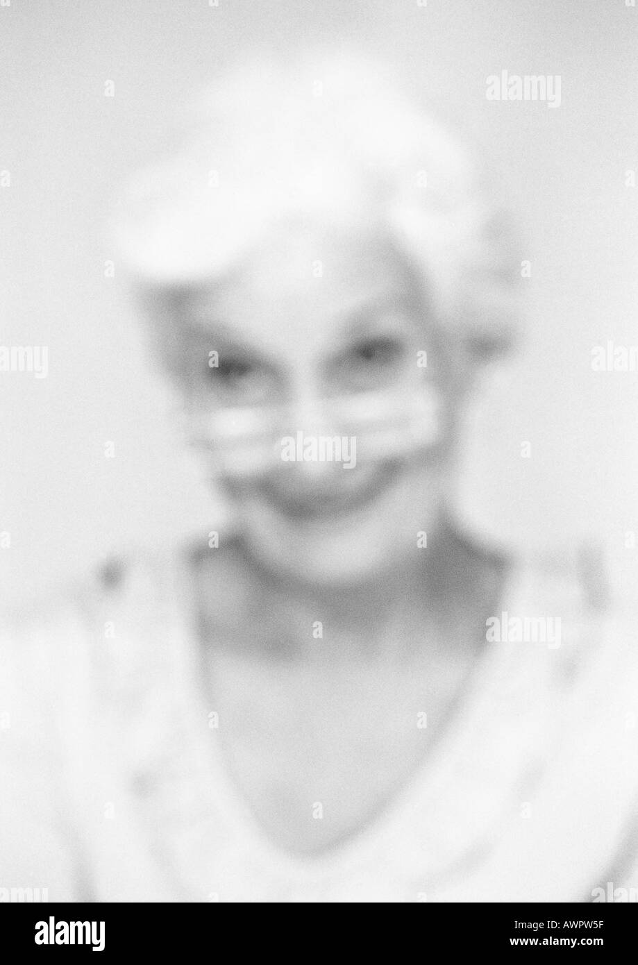 Senior woman looking over edge of glasses, close-up, portrait, blurred, b&w Stock Photo
