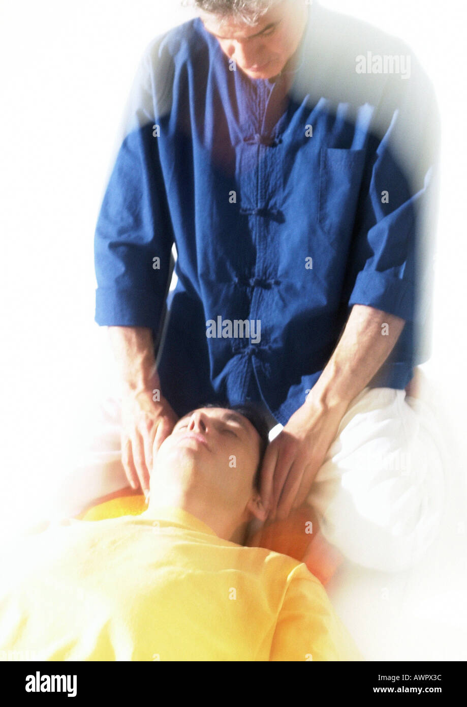 Massage therapist massaging man's head Stock Photo
