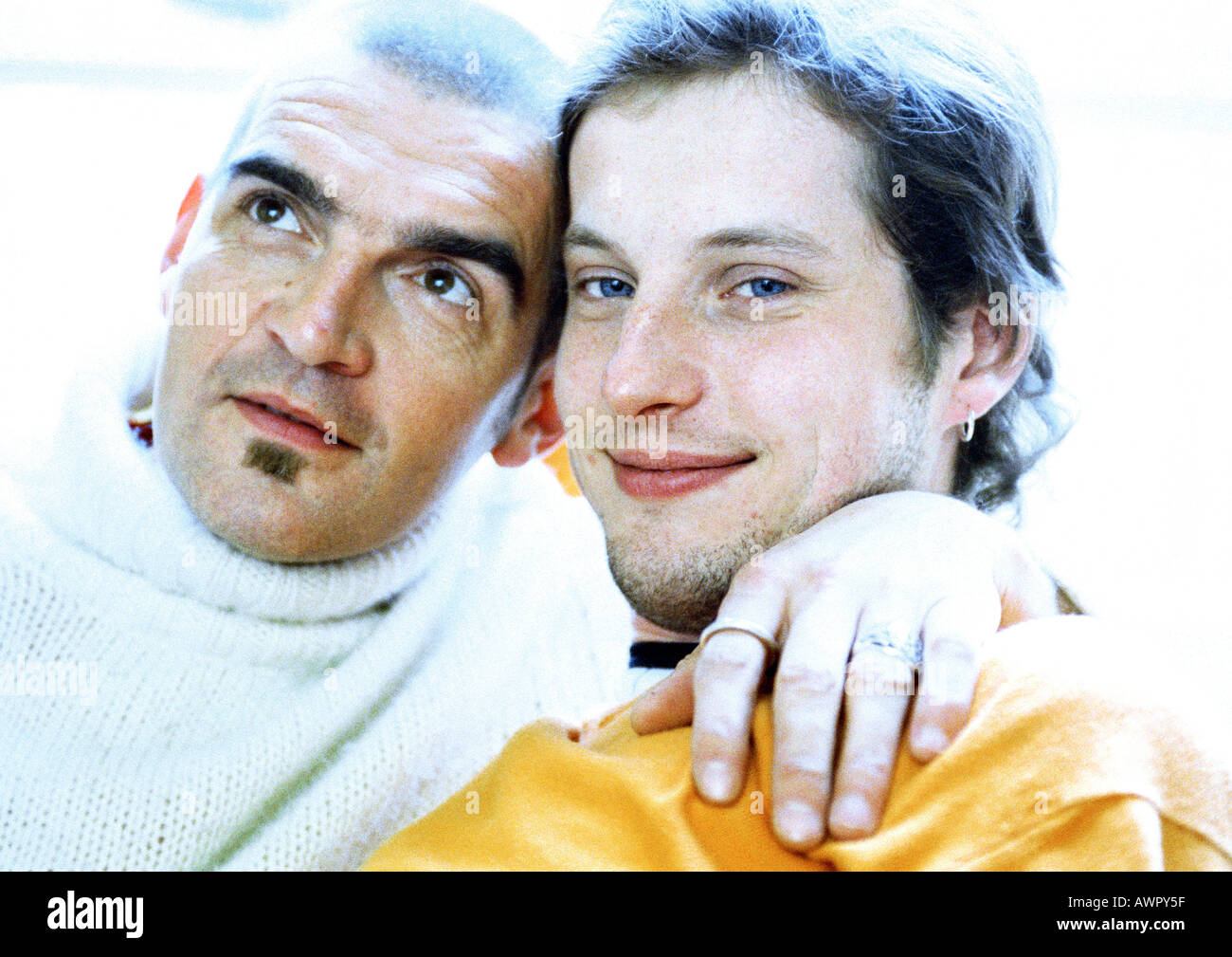 Two men sitting, man's arm around the other's neck, portrait. Stock Photo