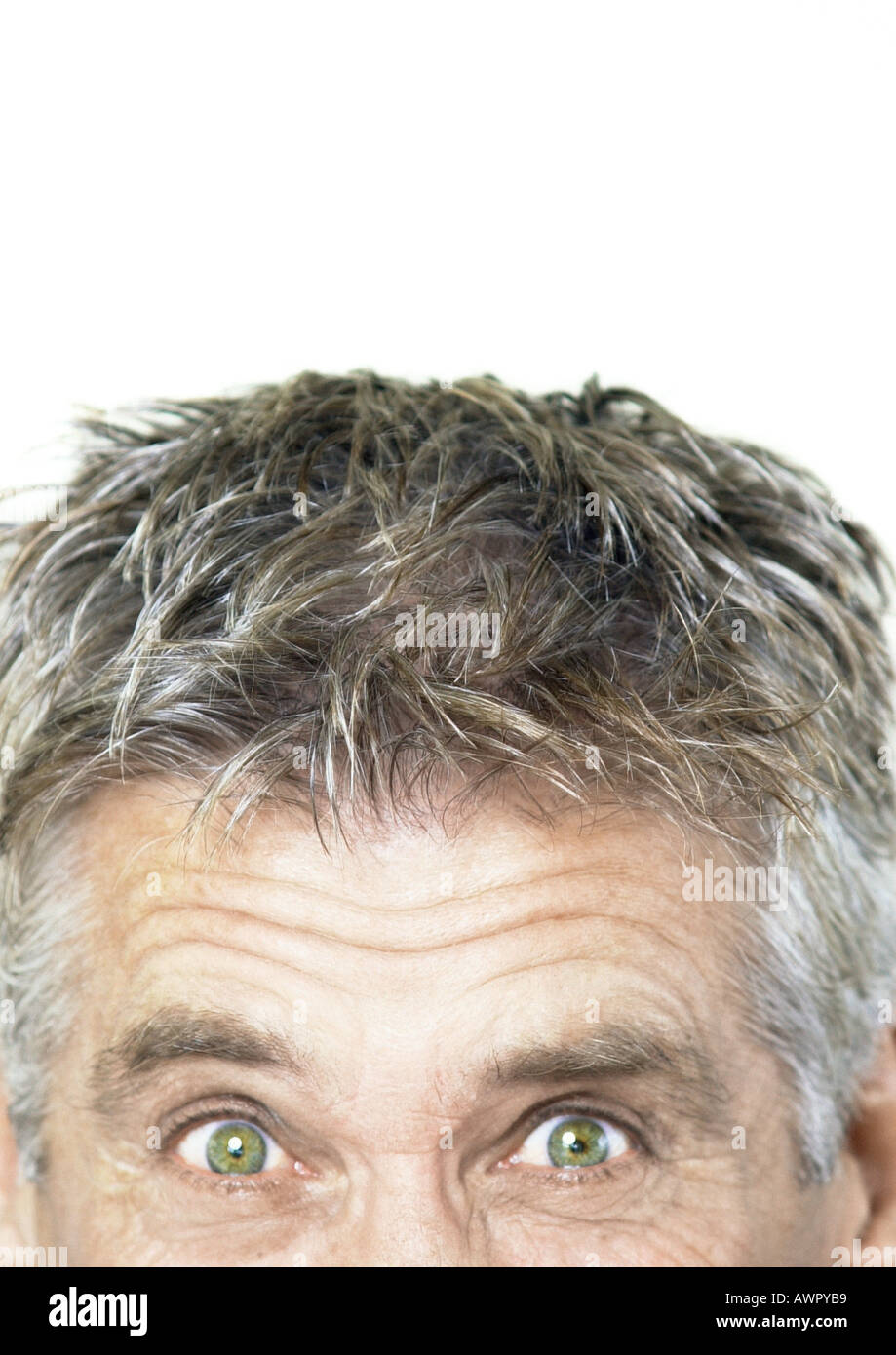 Mature man raising eyebrows and looking at camera, partial view, close-up Stock Photo