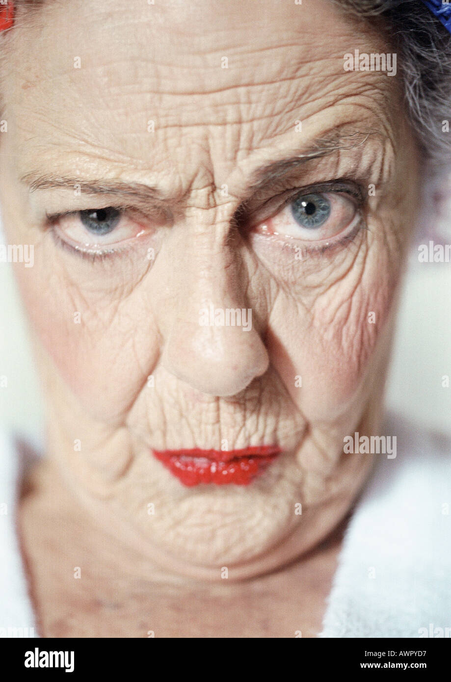 Elderly woman raising eyebrow and looking at camera, portrait, close-up Stock Photo