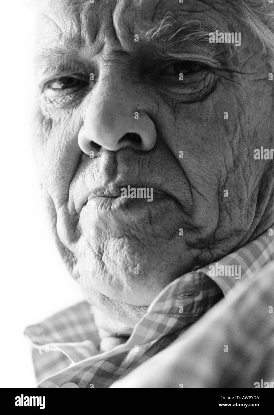 Elderly man frowning at camera, close-up, portrait, b&w Stock Photo