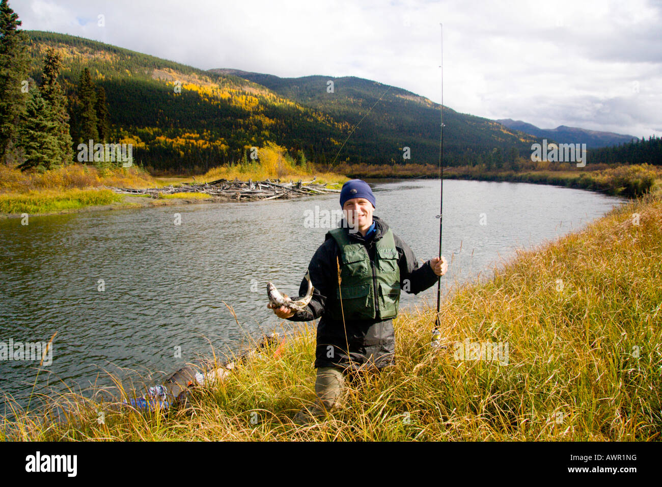 Fisherman and his catch standing on the bank of Big Salmon River, Yukon Territory, Canada Stock Photo