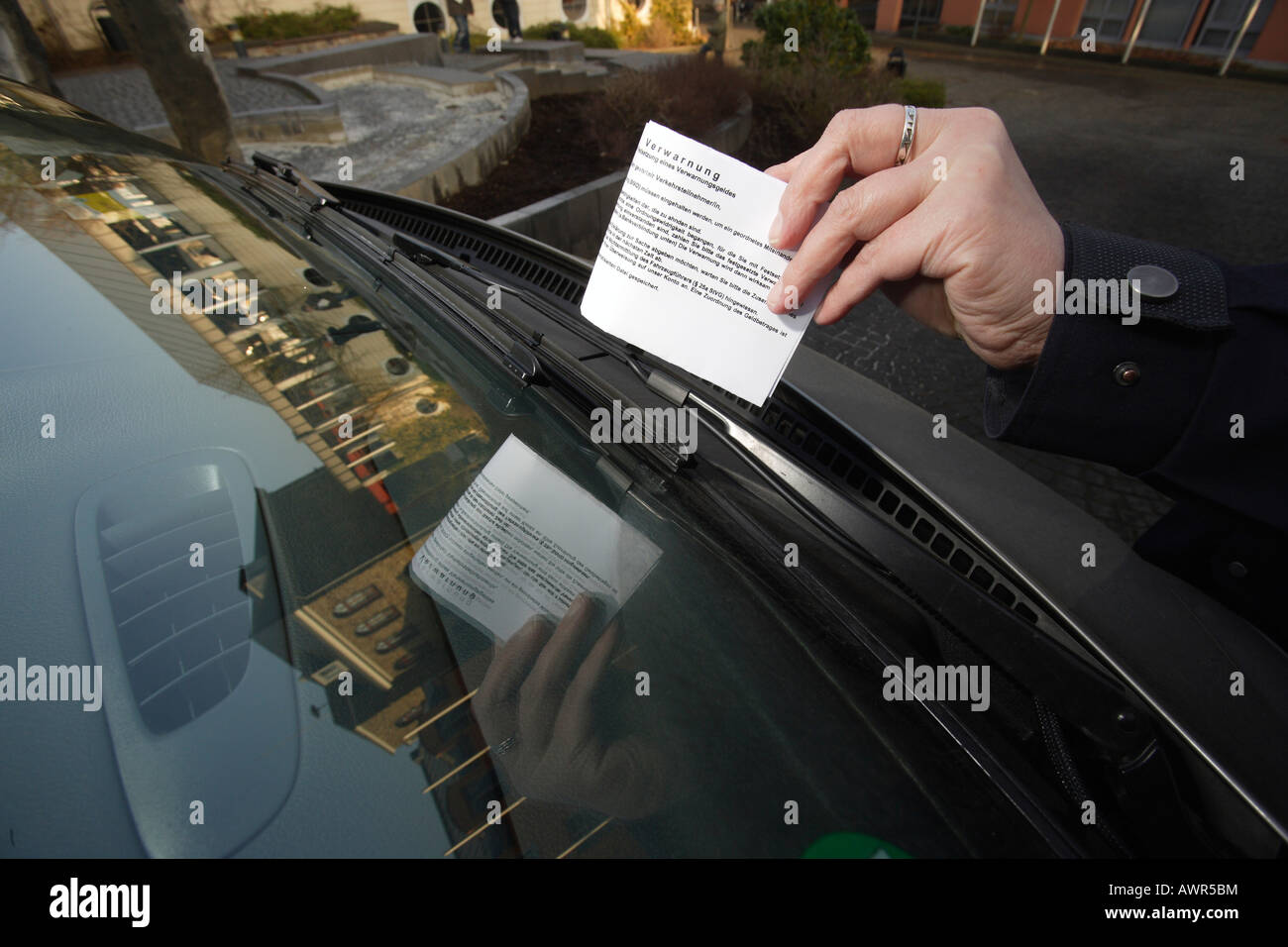 Traffic warden put a fine on the front shield Stock Photo