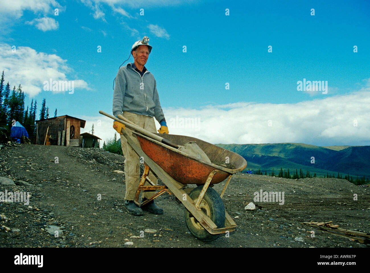 Prospector with wheelbarrow pick and shovel on his way to work