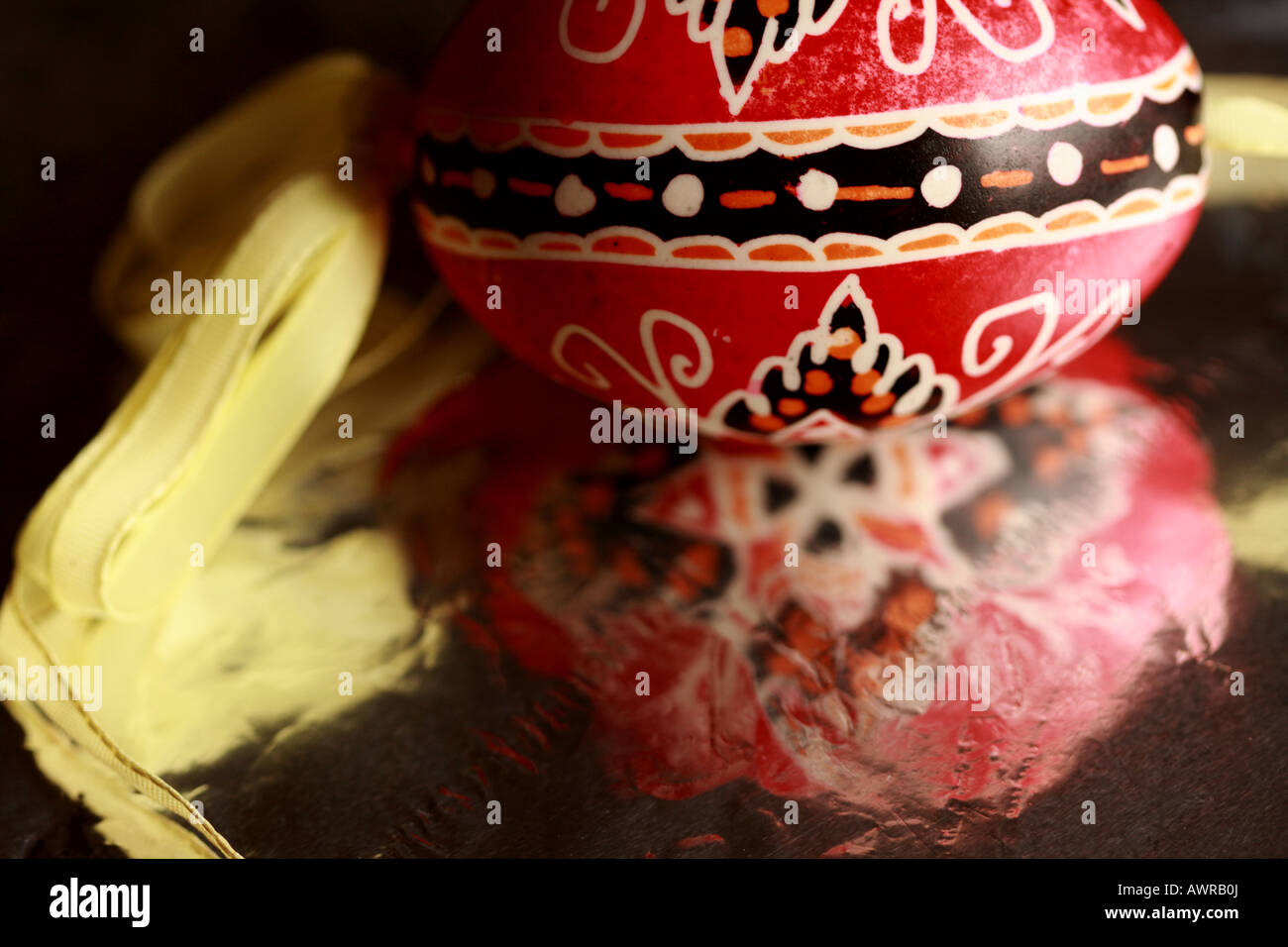 a red and black traditional Czech Easter egg reflects in silver foil Stock Photo