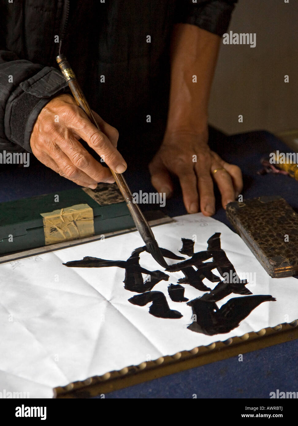 An artist paints traditional characters inside the NGOC SON TEMPLE in the old quarter HANOI VIETNAM Stock Photo
