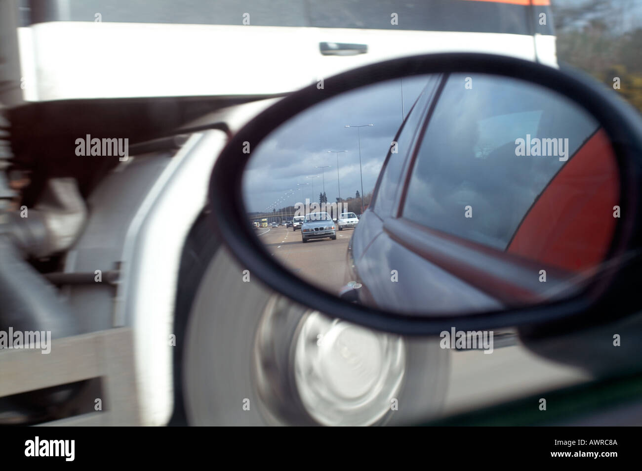 View in a car wing mirror while overtaking on a motorway Stock Photo