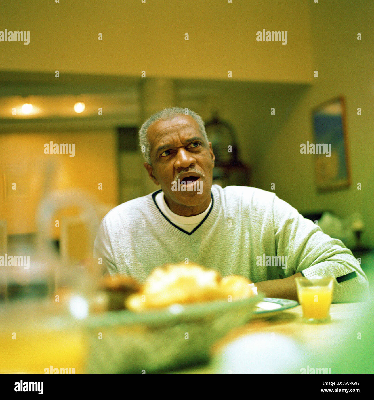 Mature man sitting at table Stock Photo