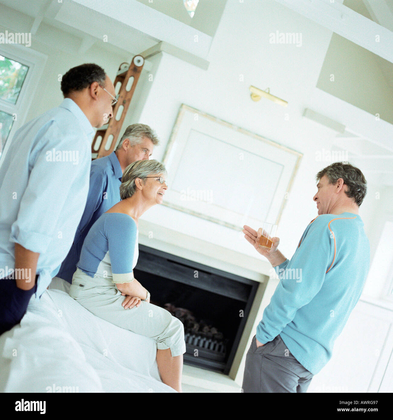 Four mature people talking in a room Stock Photo