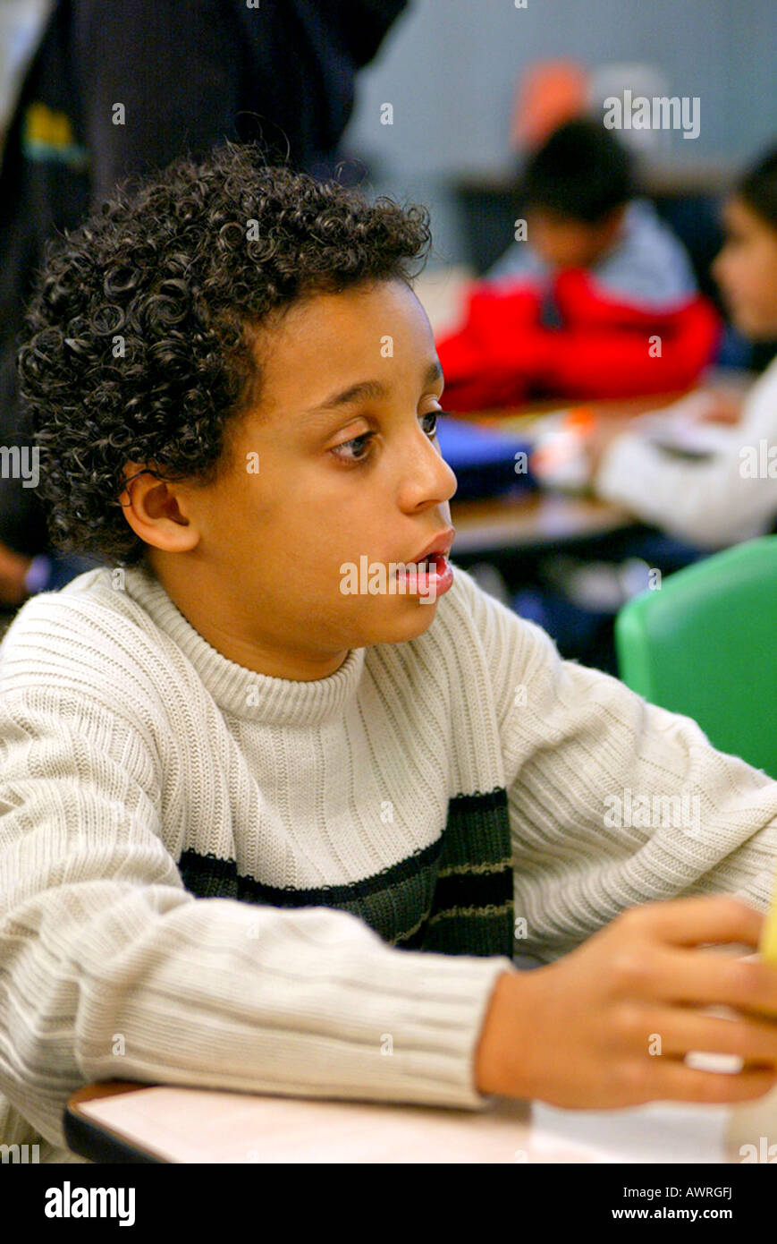 Black boy watches other children at table at recreation center Model released Stock Photo
