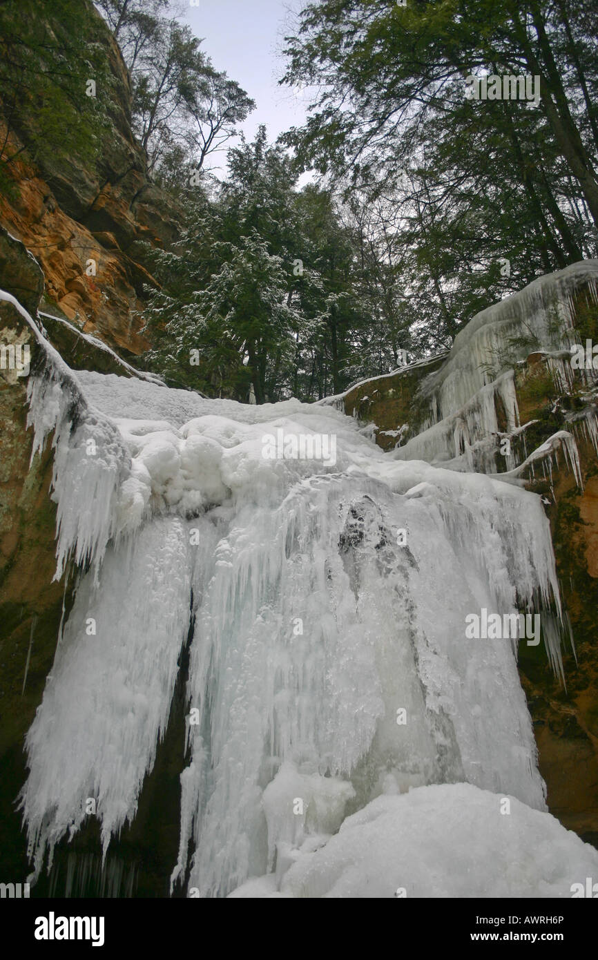 Frozen waterfall at State park Hocking Hills Ohio OH in USA US close up low angle from below sunlight background  images vertical format hi-res Stock Photo