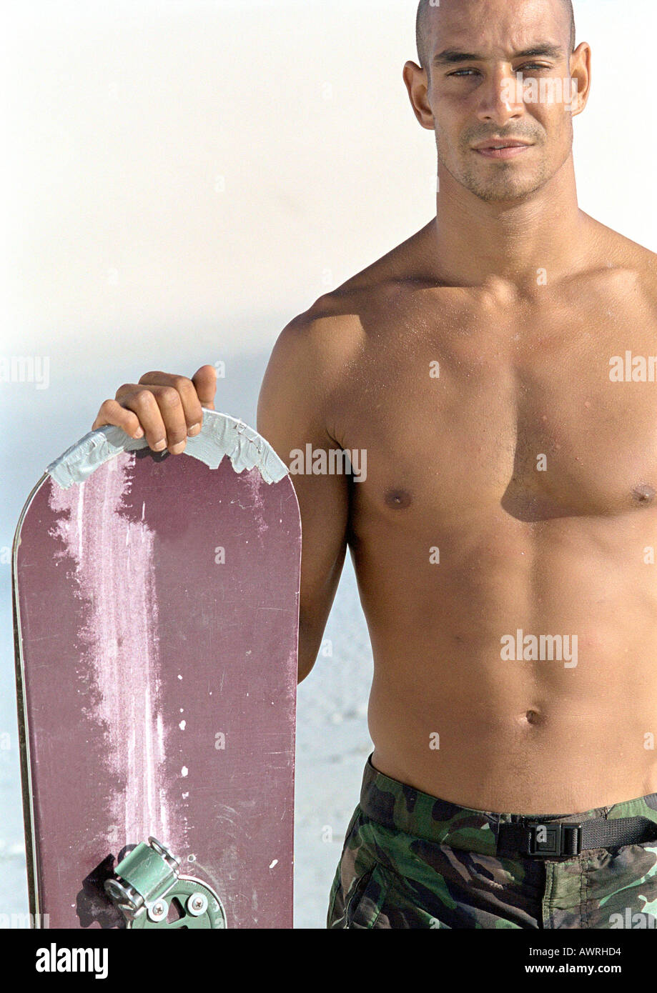 Man holding snowboard, bare-chested, portrait Stock Photo - Alamy