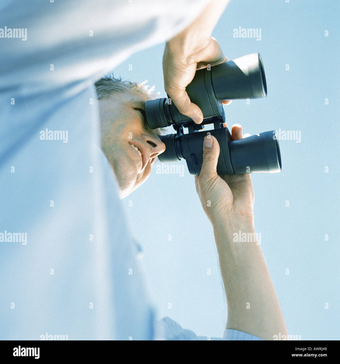 Man looking through binoculars, low angle view Stock Photo