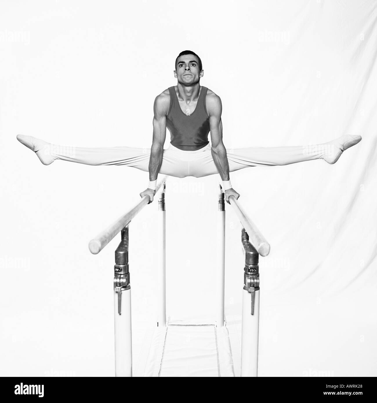 Young male gymnast on parallel bars Stock Photo