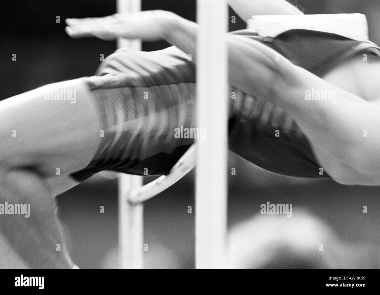 Male high jumper clearing bar, close-up, b&w Stock Photo