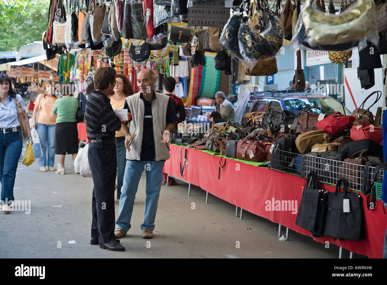 Handbag vendor talkes to customer in front of his stall at the annual