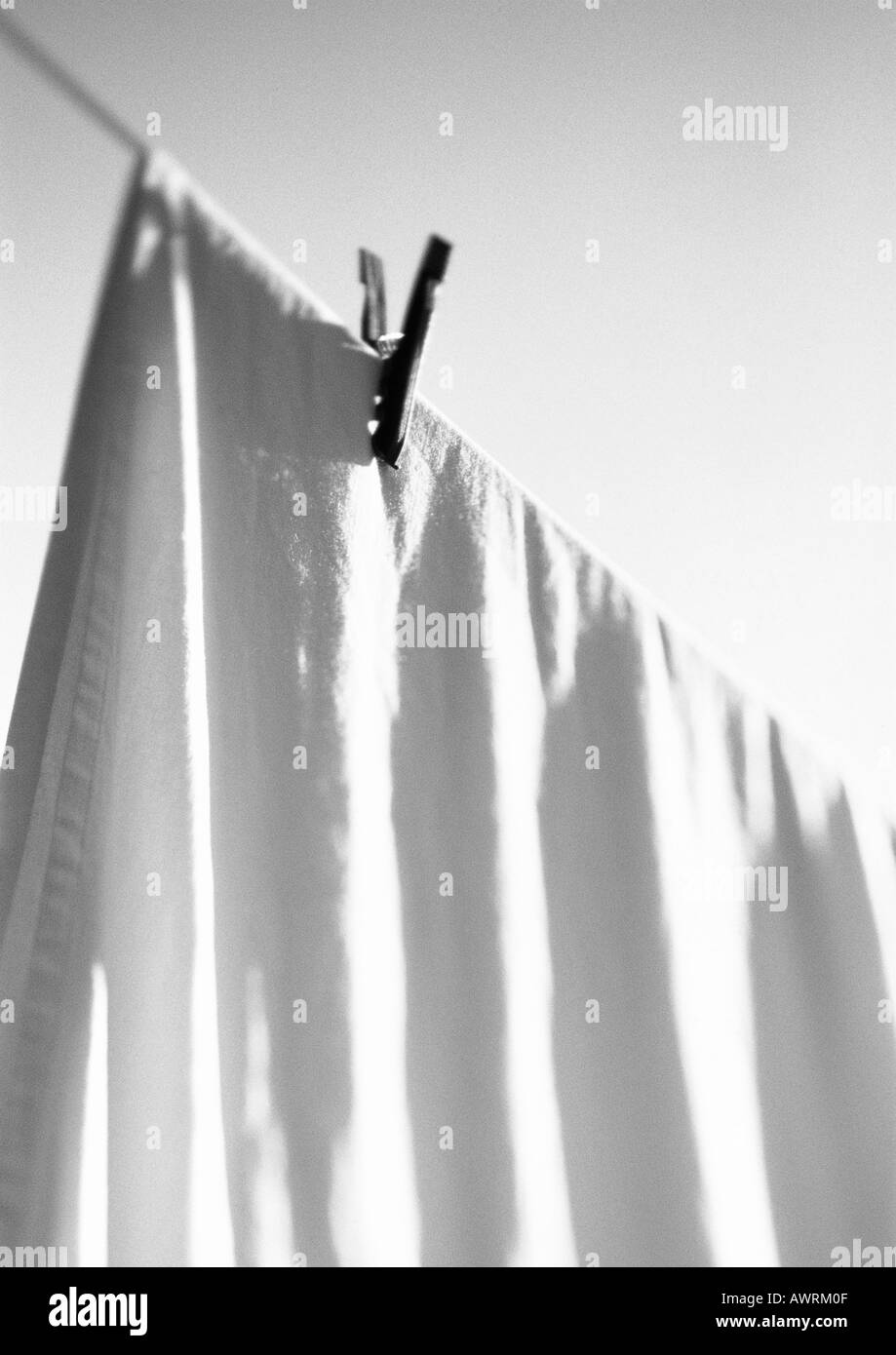 Bed sheet hanging on line with clothes pin, b&w. Stock Photo