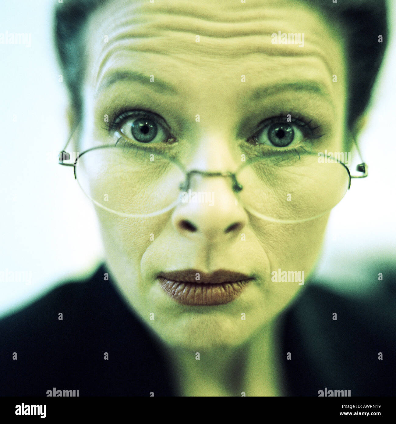 Close-up of businesswoman wearing glasses, raising eyebrows, close-up. Stock Photo