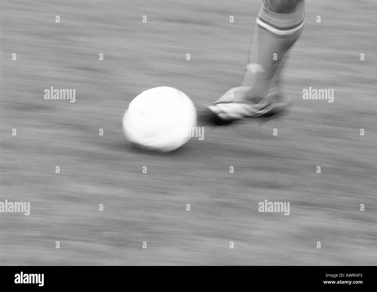 Foot of player and soccer ball, blurred, b&w. Stock Photo