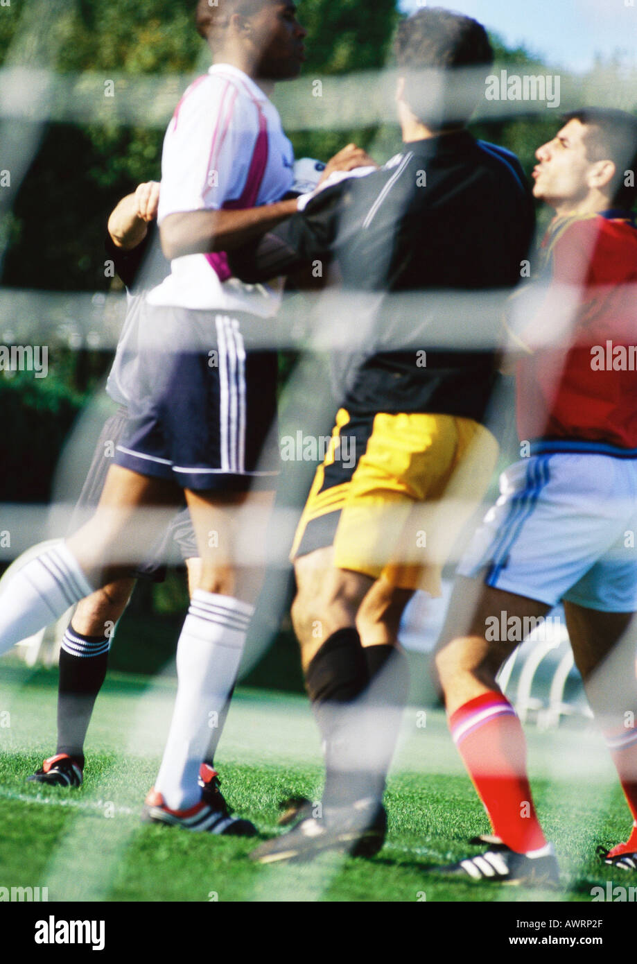 Soccer players during a match, seen from behind the goal net Stock Photo Alamy