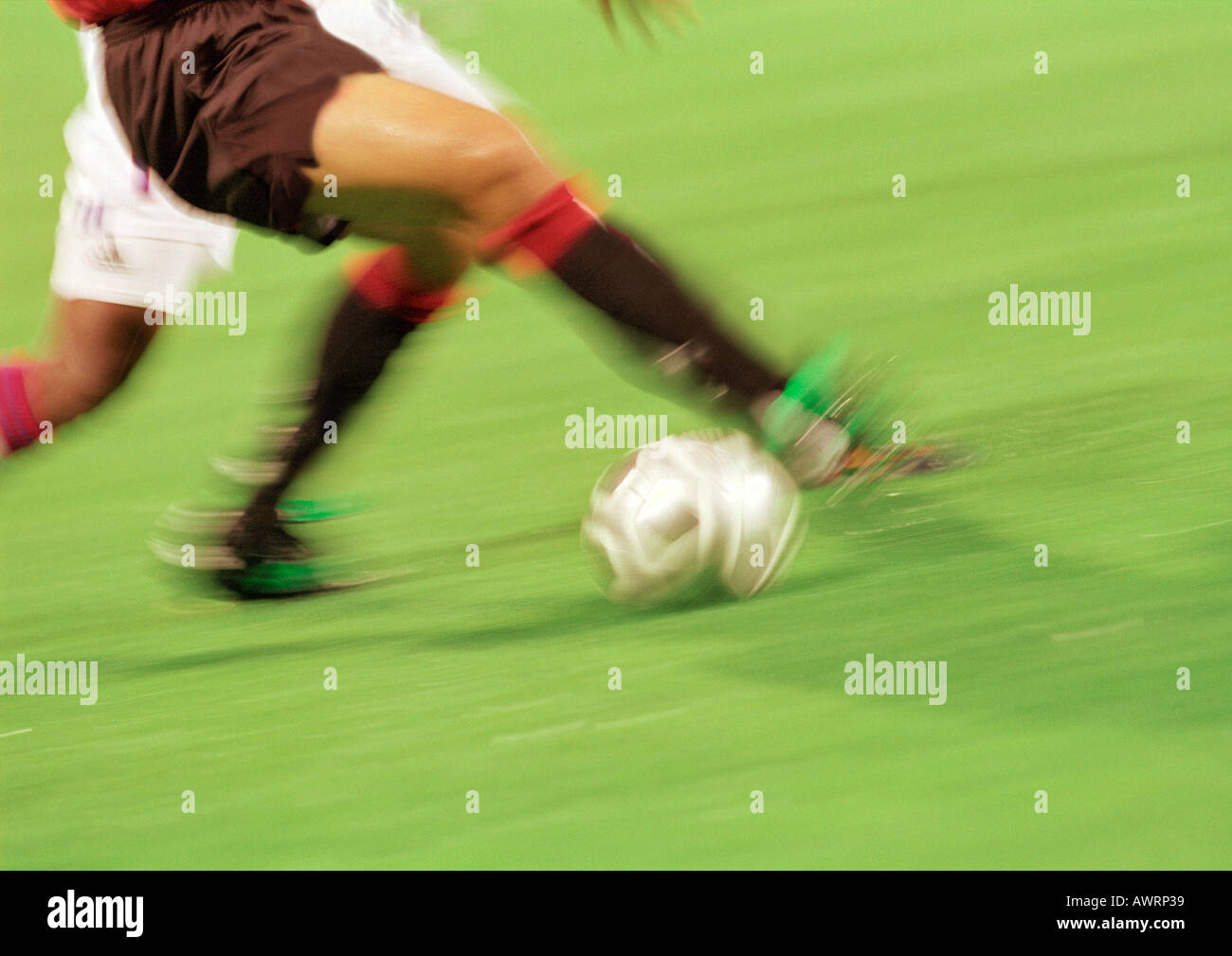 Soccer players running with ball, lower section, blurred. Stock Photo