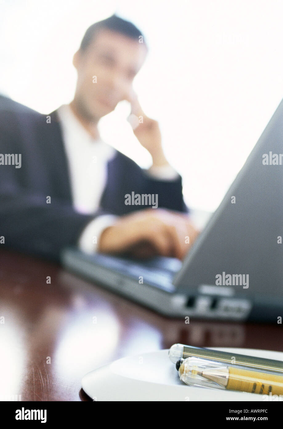Businessman using laptop computer, blurred Stock Photo - Alamy